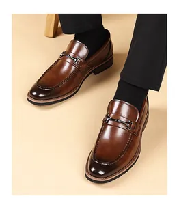 Detailed macro view of stylish brown men's leather bit loafers with polished metal buckle