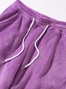 Close-up view of soft purple fuzzy fleece fabric and white drawstring detail on casual pants