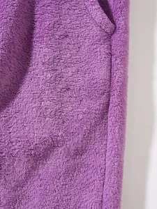 Macro detail of the soft purple fleece fabric texture on warm winter trousers for men