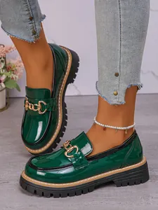Dark green patent leather loafers with gold chain buckle and chunky platform sole