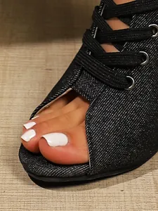 Close-up of black denim lace-up peep toe sandals showing material and toe detail