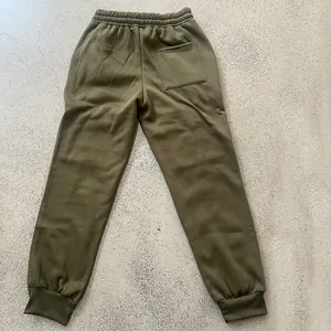 Detail view of olive green heavyweight fleece joggers with back pocket and elastic cuffs.