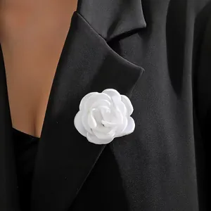 Detaillierte Makroansicht einer handgefertigten 6 cm weißen Kamelienblüten-Brosche an einem Blazer