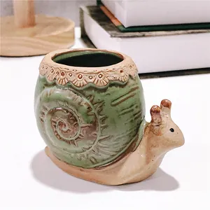 Vue latérale d'un pot de fleurs décoratif en céramique en forme d'escargot vert