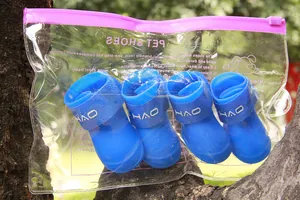 Vista ravvicinata di stivali da pioggia per cani in silicone blu in una custodia trasparente.