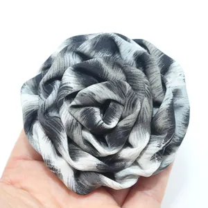 Dettaglio di una rosa in tessuto con stampa leopardata per accessori di abbigliamento DIY.