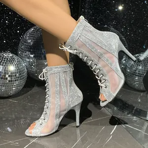 Vista detallada de botines plateados con purpurina, tacón alto y diseño de malla con cordones