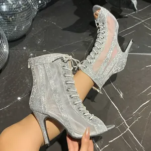 Detalle de botines plateados brillantes con paneles de malla y cordones delanteros
