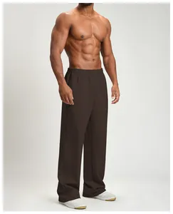 Detailed side view of men's dark brown wide-leg sports pants on an athletic model