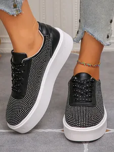 Detailaufnahme schwarzer Damen-Plateausneaker mit Nietentextur und dicker weißer Sohle