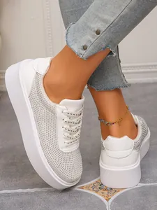 Detailansicht weißer Plateau-Slipper mit funkelnden Strasssteinen und Mesh.