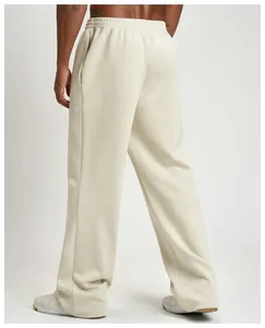 Detail of men's cream-colored wide-leg joggers showing the back fit and fabric texture.