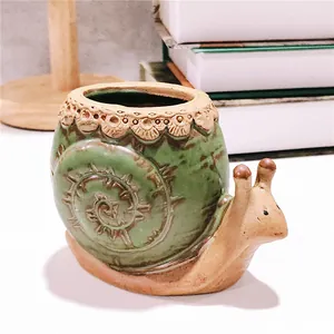 Vue macro détaillée d'un joli pot de fleurs en céramique en forme d'escargot pour succulentes
