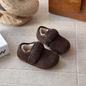 Close-up of brown wool felt children's shoes with warm fleece lining and strap.