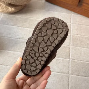 Detailed macro view of the non-slip rubber sole on brown wool children clogs size 23
