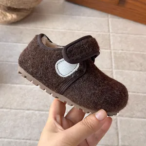 Detail of brown children's wool felt shoes with soft sole and fuzzy interior