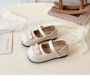 Detailed view of beige girls Mary Jane shoes with elegant bow and shell toe design.