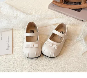 Top view of girl's beige leather Mary Jane shoes with delicate bow details