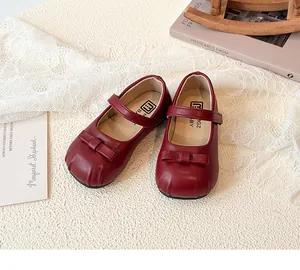 Detailed view of elegant red girl's Mary Jane leather shoes with a charming bow accent