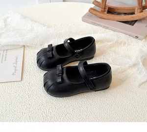 Detailed view of black girls' Mary Jane leather shoes with bow and textured round toe