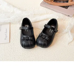 Close-up detail showing the elegant black girls' Mary Jane shoes with bow decoration
