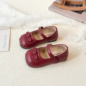 Elegant red Mary Jane leather shoes for girls with bow detail on white lace background