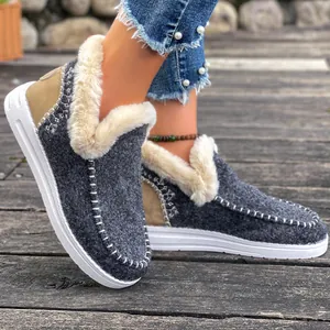Détail de bottes de neige en feutre gris pour femme avec fourrure blanche et semelle