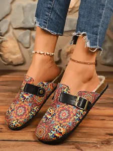 Close-up of ethnic printed clogs with faux fur lining and adjustable buckle straps.