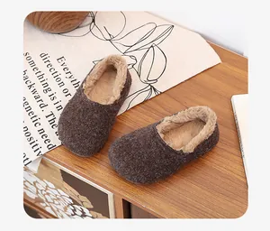 Close-up of warm fleece-lined brown winter slippers on a cozy wooden desk