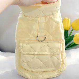 Close-up of quilted yellow pet vest featuring a practical D-ring harness attachment