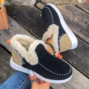 Vue détaillée de bottes de neige en daim noir avec doublure en fausse fourrure blanche.