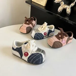 Macro view showing detailed patchwork and stitching of the toddler sneakers.