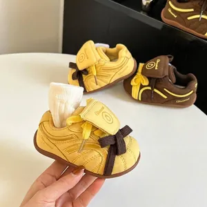 Vista detallada de zapatillas de deporte para niños pequeños amarillas y marrones con ante.