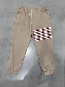 Detailweergave van de khaki fleece herenjoggingbroek met strepen en trekkoord in de taille