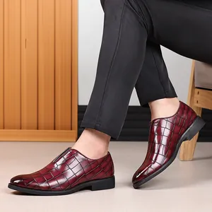 Zapatos de vestir para hombre en cuero burdeos con grabado de cocodrilo y pantalón negro.