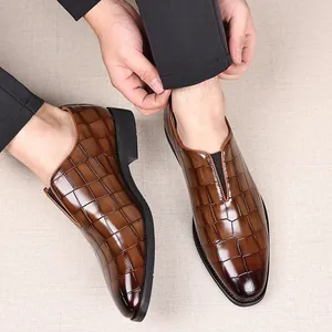 Vista detallada de zapatos de cuero marrón para hombre con motivo de cocodrillo slip-on.