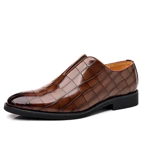 Nahaufnahme brauner Herren-Business-Schuhe mit Krokodilmuster und spitzer Zehenpartie