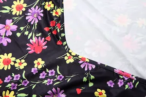 Nahaufnahme von lebhaftem Blumendruck und Nähten auf schwarzem Sommerkleid