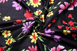 Nahaufnahme eines bunten Blumenmusters auf schwarzem Stoff mit lebhaften Blüten