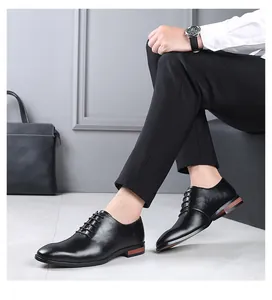 Vue de côté de chaussures Oxford classiques en cuir noir à bout pointu et pantalon