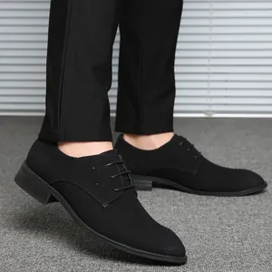 Classic black suede lace-up dress shoes for men in a professional indoor setting