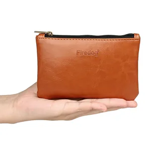 Portable brown PU leather tobacco pouch with zipper closure being held in hand for scale
