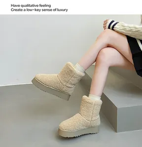 Primo piano di stivali da neve beige in ecopelliccia con suola spessa platform su modella.