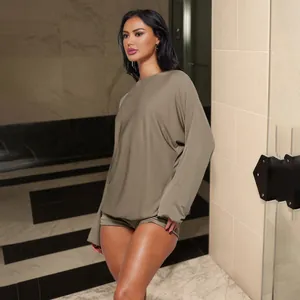 Professional model wearing an olive green long-sleeved romper in a luxury hotel setting