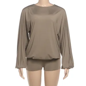 Detailed view of olive green long-sleeve jumpsuit with lantern sleeves