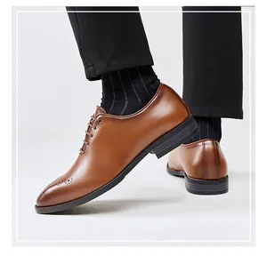 Macro detail view of brown leather brogue oxford shoes worn with elegant suit trousers