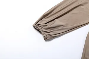 Macro detail of the elasticated cuff on a stylish taupe long-sleeved fashion jumpsuit.