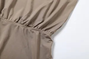 Close-up detail of high-quality elastic waist stitching on a solid brown fashion jumpsuit