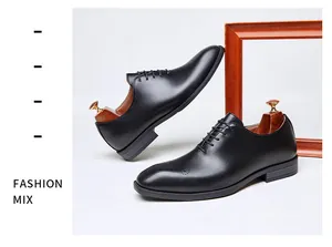 Close-up detail of black leather brogue oxford shoes featuring elegant carved patterns.