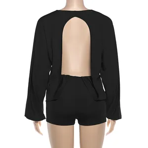 Detailed back view of a sexy black long sleeve romper with a deep open back design